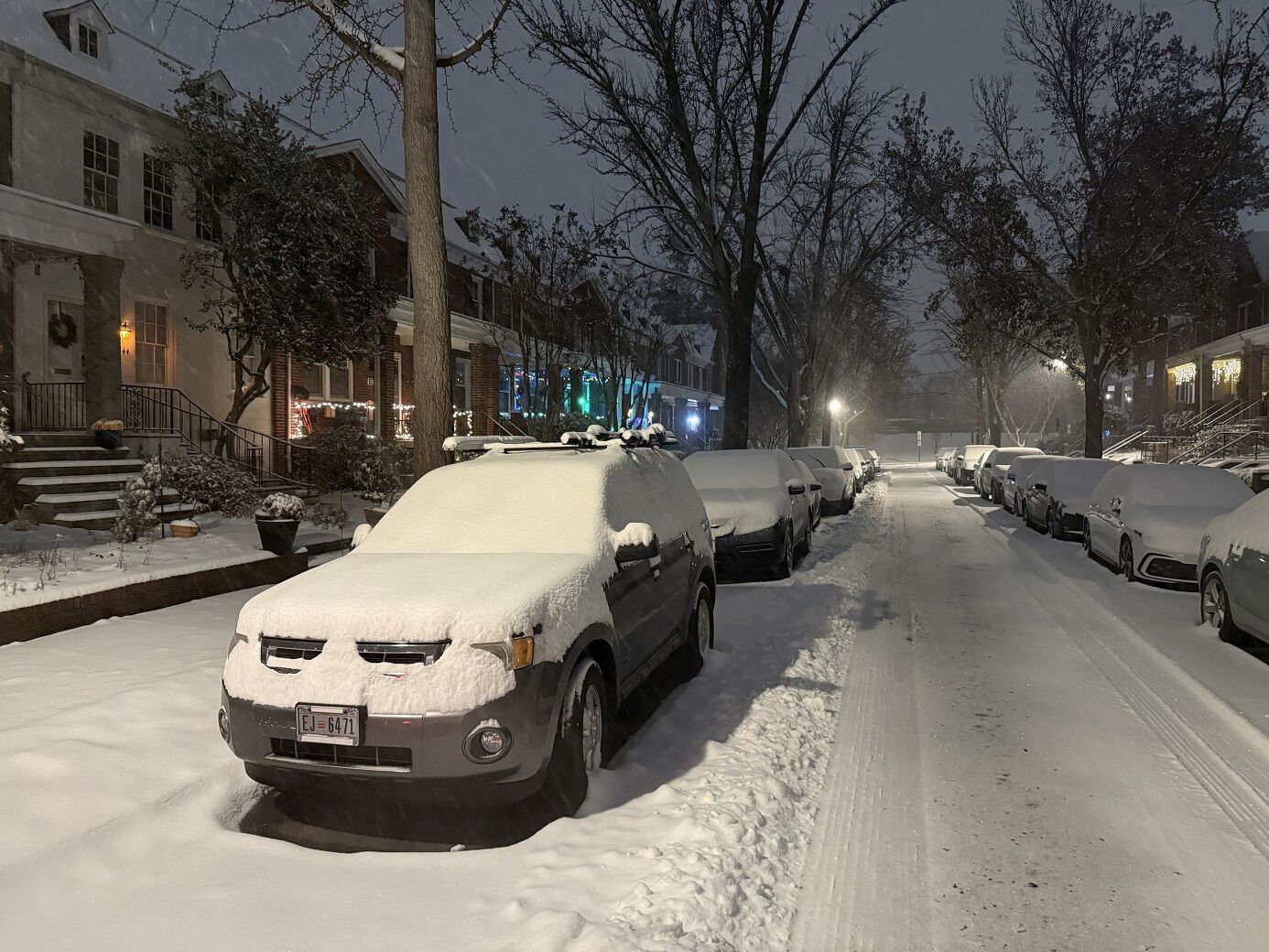 Cars covered in snow in a neighborhood