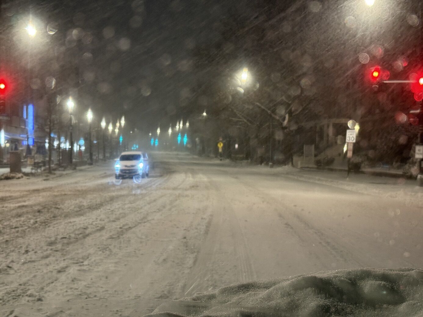 Snowy street with oncoming car