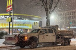 Snow plow driving through snowstorm