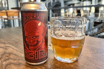 a can of beer next to a cup