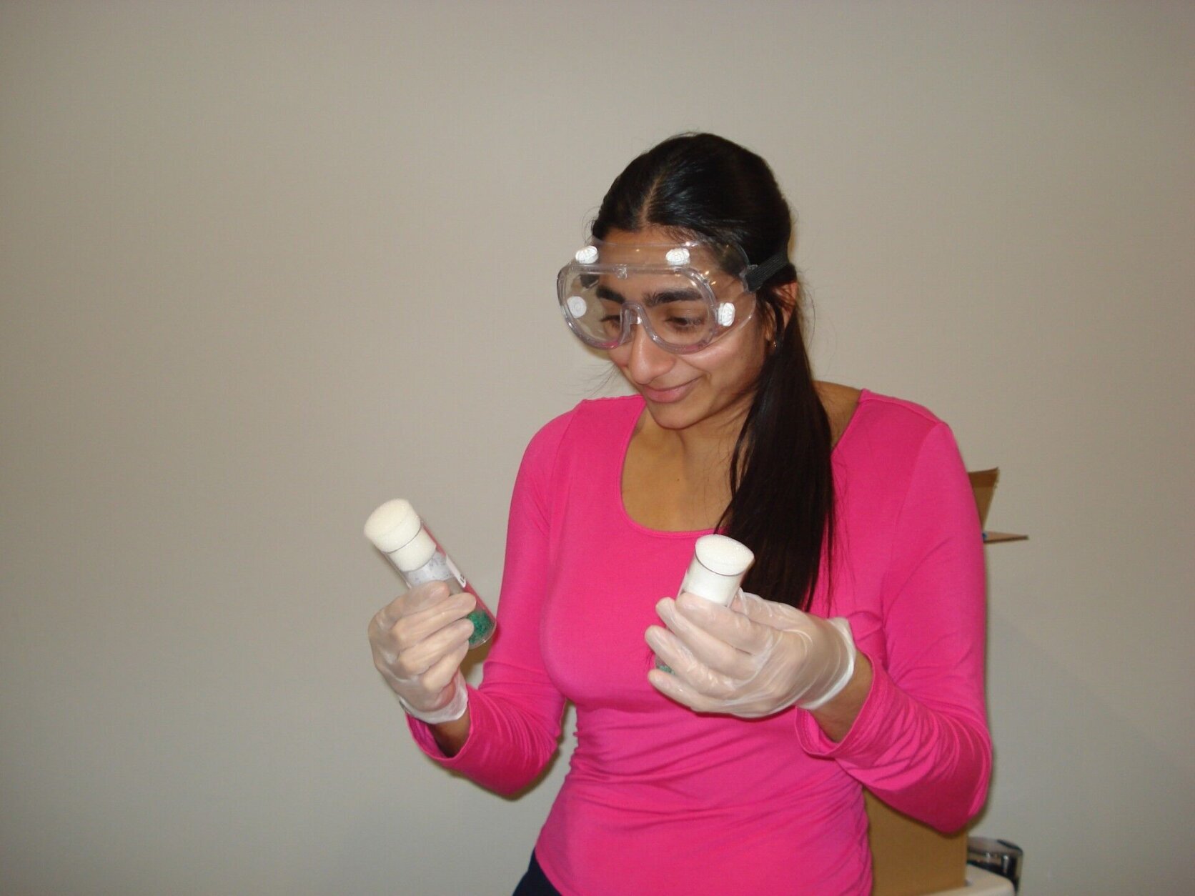 Student holding bottles and wearing glasses