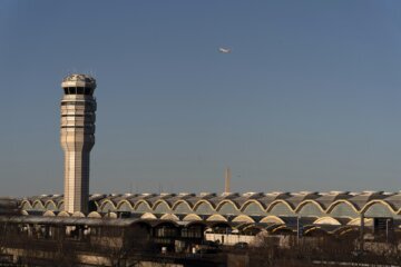 Air traffic control tower seen against a clear sky.
