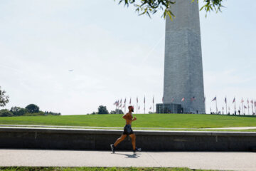 Jogger runs by the Washington Monument on the National Mall