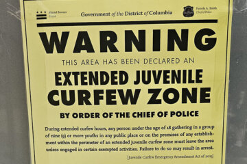 A sign detailing the extended juvenile curfew zone on the U Street Corridor is posted at a bus stop in Northwest D.C.
