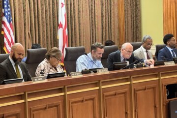 Members the dc city council sitting behind a dais