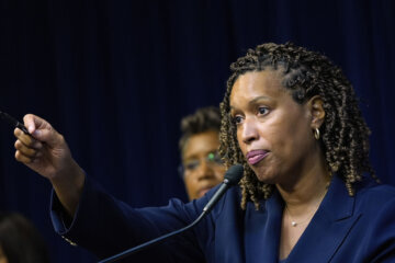 Mayor Muriel Bowser at a mic gesturing.