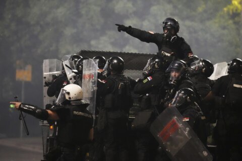 Tensions soar in Serbia as angry protesters clash with police, set fire to party offices