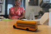 a figurine of a school bus sits on a desk