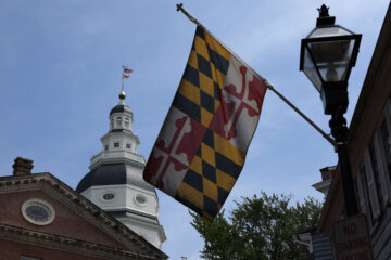 maryland state house with state flag flying in front