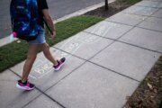 A student walks past a welcome back note on the first day of D.C. Public Schools outside an elementary in D.C. on Aug. 25, 2025, as a show of support as Immigration and Customs Enforcement (ICE) and federal agent raids increase in the city.