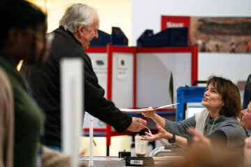 election worker hands a voter his ballot