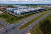 A photo of cars driving past a data center in Ashburn, Virginia.
