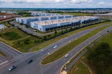 A photo of cars driving past a data center in Ashburn, Virginia.