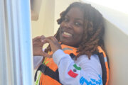 Zahara Weeks smiles while wearing a lifejacket as she prepares to swim in the Atlantic Ocean.