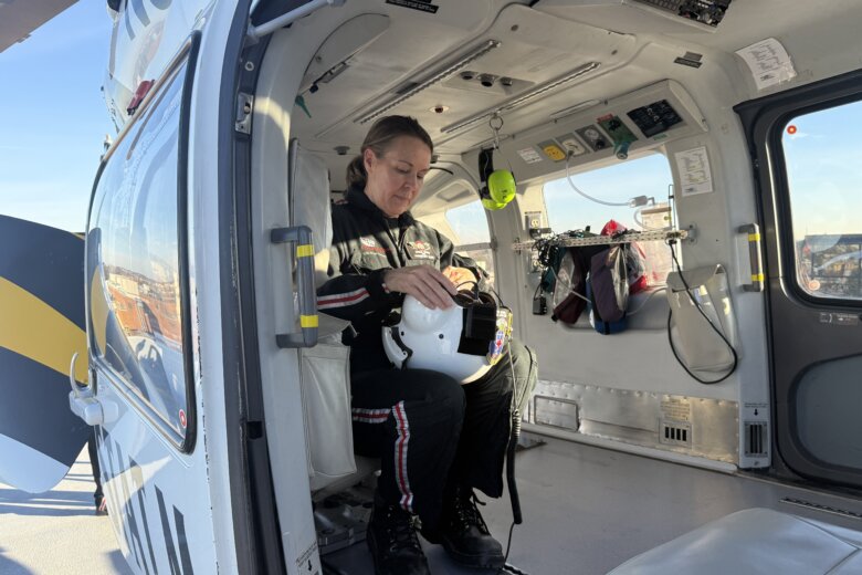 woman fixes a helmet inside an aircraft