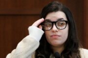 close up image of woman wearing glasses testifying in court