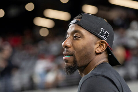 FILE - Atlanta Falcons offensive assistant quarterbacks coach D.J. Williams warms up players before coaching against the Las Vegas Raiders in an NFL football game, Dec. 16, 2024, in Las Vegas. (AP Photo/Jeff Lewis, File)