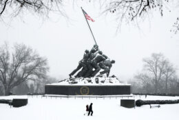 People walk past the Marine Corps War Memorial