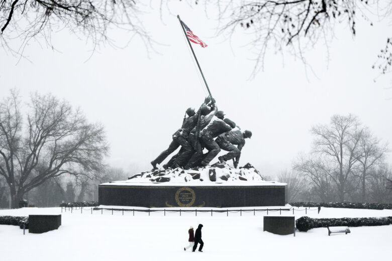 People walk past the Marine Corps War Memorial
