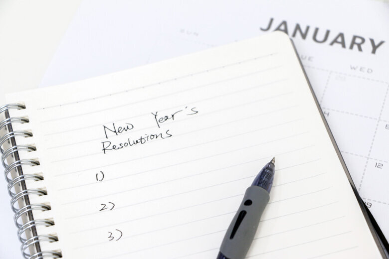 Writing New Year's resolutions list on notepad with ballpoint pen