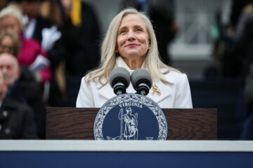 woman speaking at podium with microphones