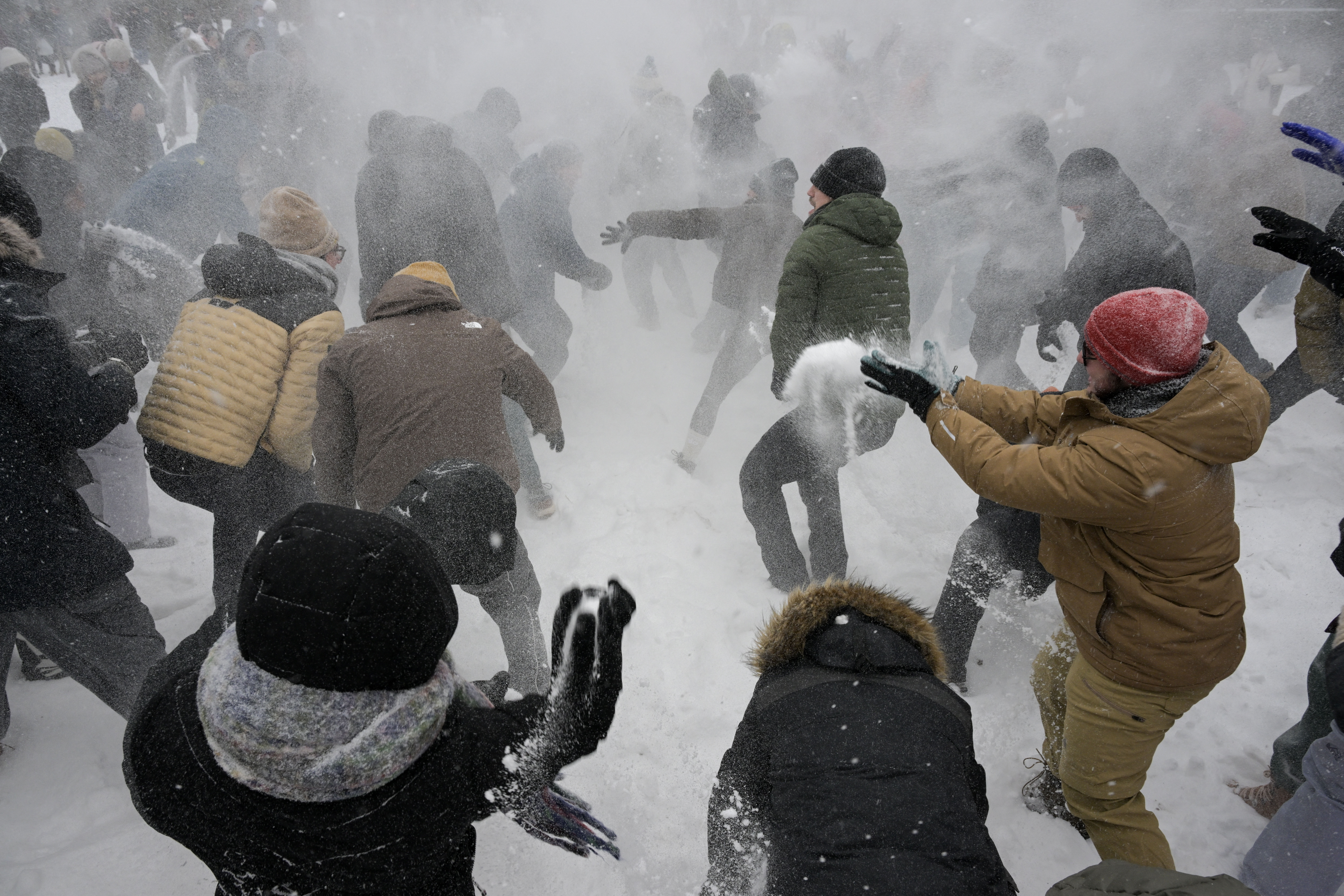 large crowd participates in snow ball fight pictured from slightly above