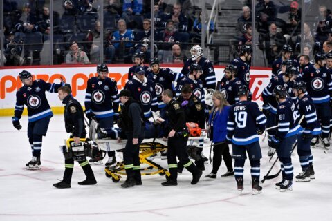 Jets D Fleury alert, moving extremities after taken off ice on stretcher after collision with boards