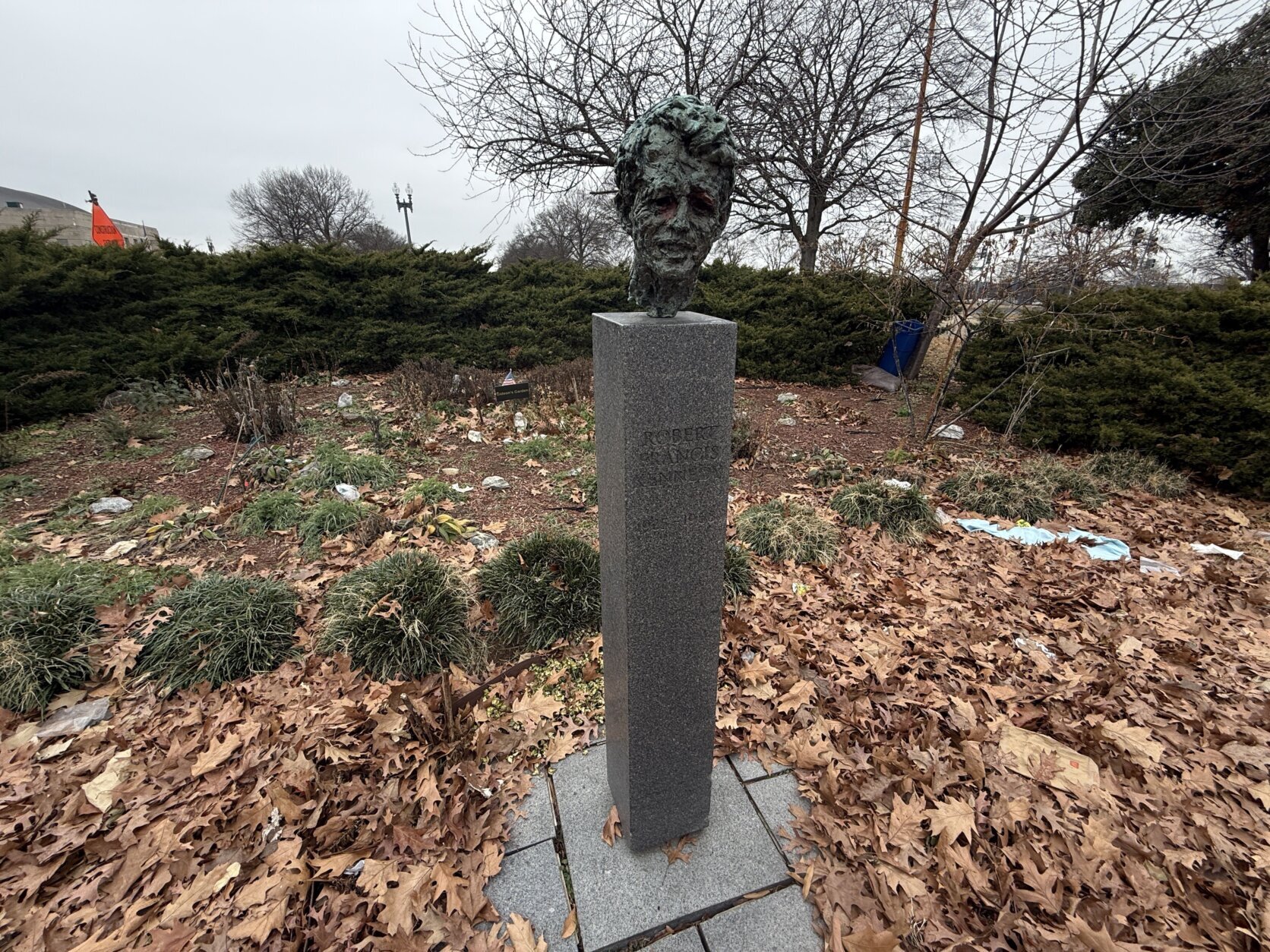 a bust of a man's face stands outside