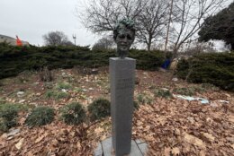 a bust of a man's face stands outside