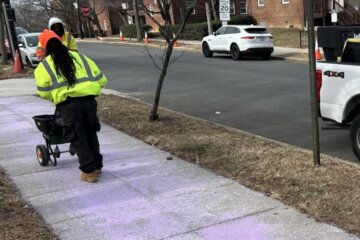 Workers with D.C.’s Department of General Services pretreat a walkway ahead of the snow.