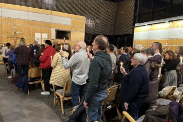 people stand holding candles