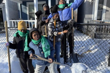 group of kids shoveling snow