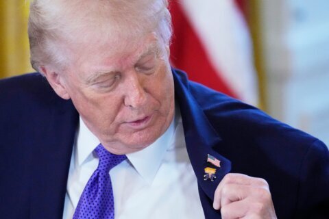 Trump wears a new ‘Happy Trump’ lapel pin, but insists he’s never happy