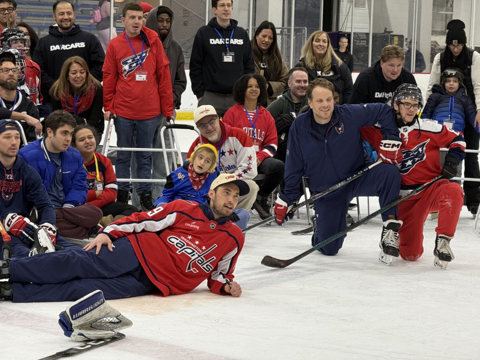 kids pose on the ice with capitals players