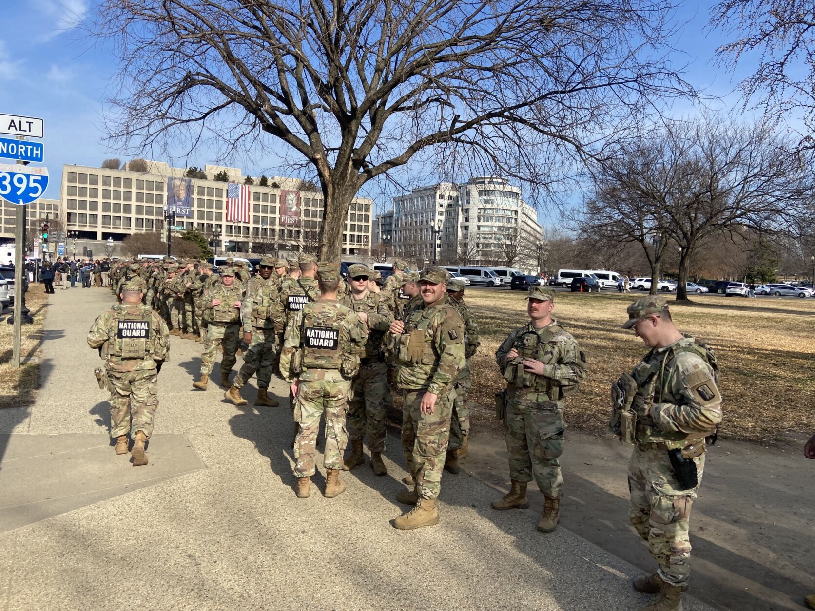 national guard stand on sidewalk