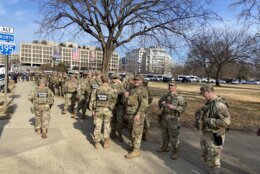 national guard stand on sidewalk