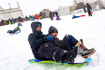 two people on a sled on snowy capitol hill