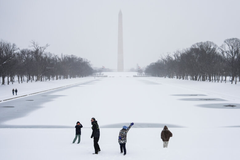 People walking along the National Mall while snow is falling