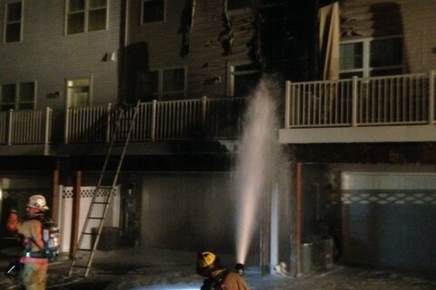 firefighters spray water on a home