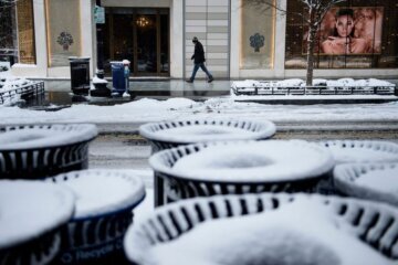A man walks past snow covered trash cans during a winter storm January 13, 2019 in Washington, DC. - Washington area residents woke up to a winter wonderland, and may need to shovel aside several inches of snow that fell overnight as a winter storm warning remains in effect until 6 p.m. Sunday and more snow is expected to fall. (Photo by Brendan Smialowski / AFP)        (Photo credit should read BRENDAN SMIALOWSKI/AFP via Getty Images)