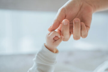 Close-up little hand of child baby holding hand of mother
