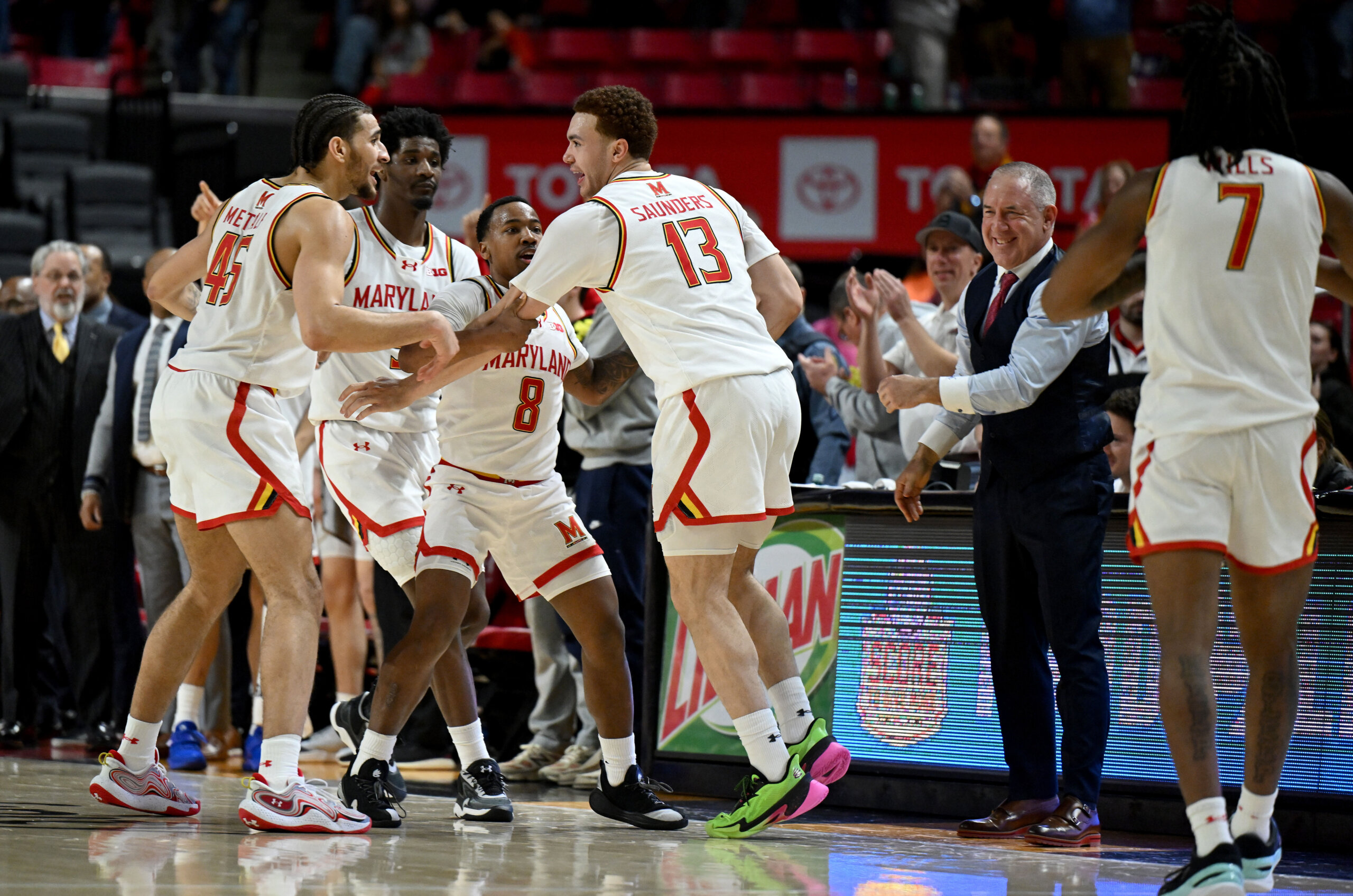basketball players celebrate on court near sideline