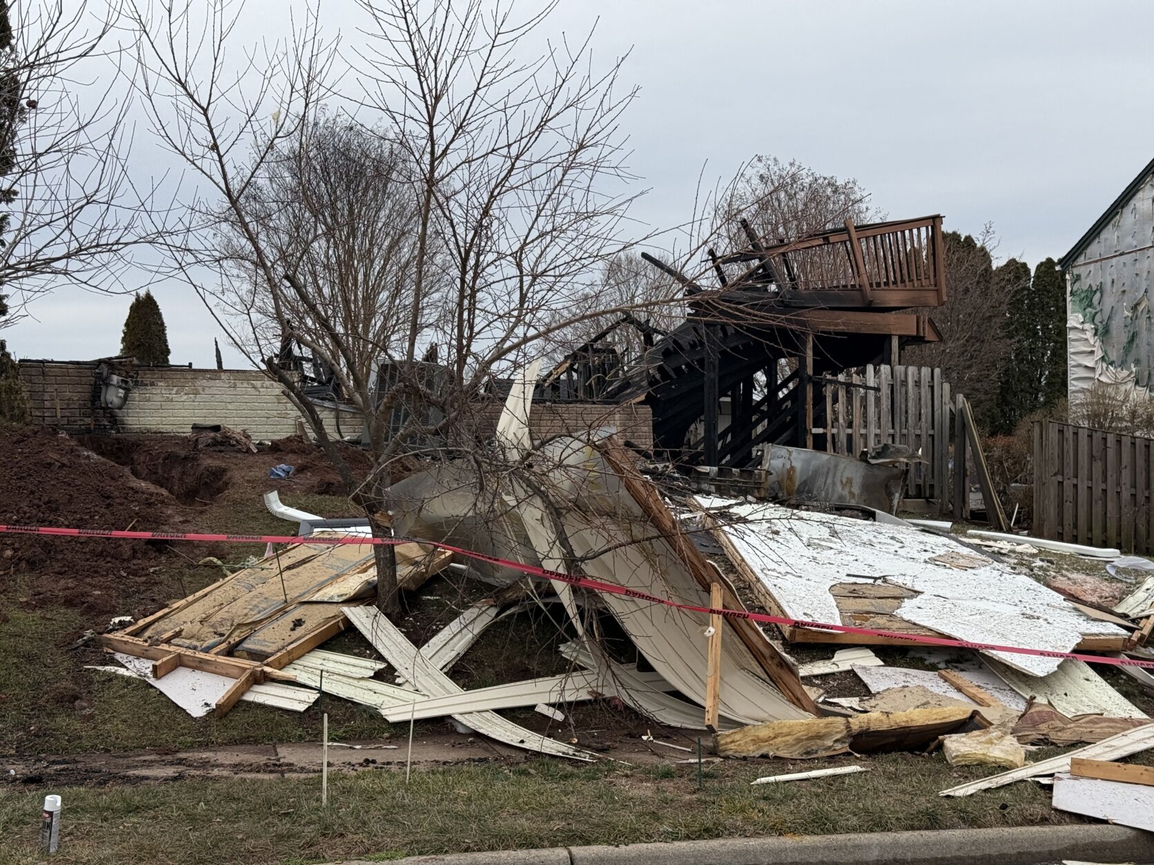 rubble is seen after a home explosion in a suburban neighborhood