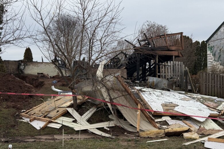 rubble is seen after a home explosion in a suburban neighborhood
