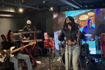 woman singing on stage with band