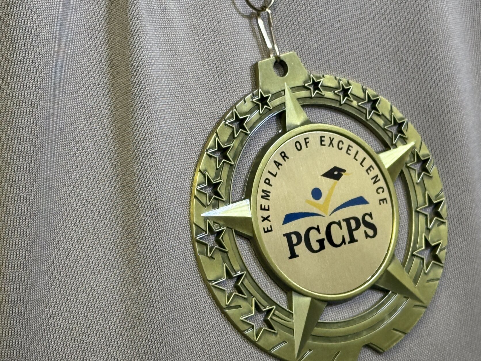 A medal that reads "Exemplar of Excellence PGCPS"