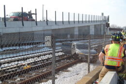 car seen through fencing sitting on metro train tracks