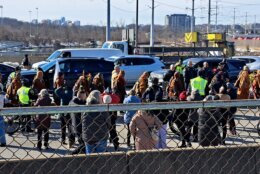 People pass flowers to the monks as they walk past Potomac Yard on Feb. 9, 2026.