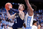 Navy guard Austin Benigni (1) drives against North Carolina forward James Brown, right, during the second half of an NCAA college basketball game, Tuesday, Nov. 18, 2025, in Chapel Hill, N.C. (AP Photo/Chris Seward)