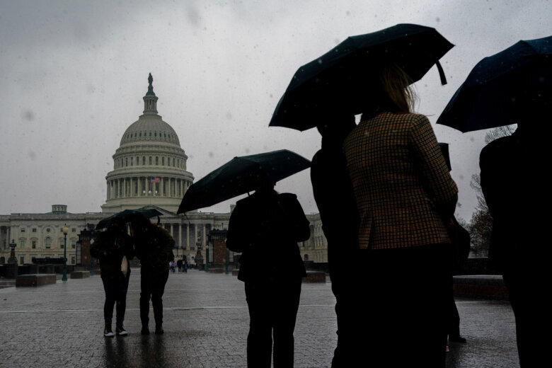 Visitors carrying umbrellas during heavy rain walk past the U.S. Capitol on Capitol Hill in Washington, Monday, March, 16, 2026. (AP Photo/Nathan Howard)